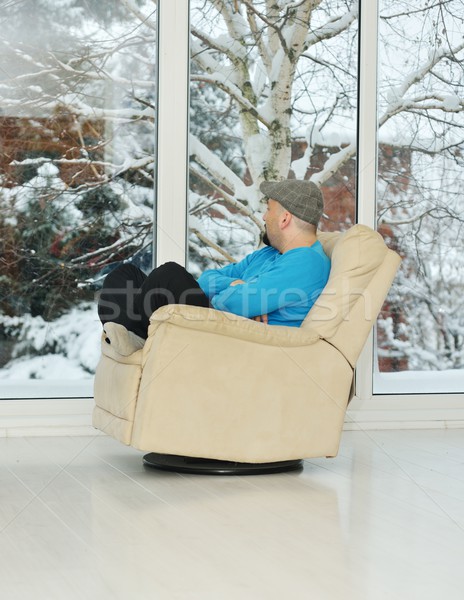 Young man relaxing on a white sofa at home by winter snow time Stock photo © zurijeta