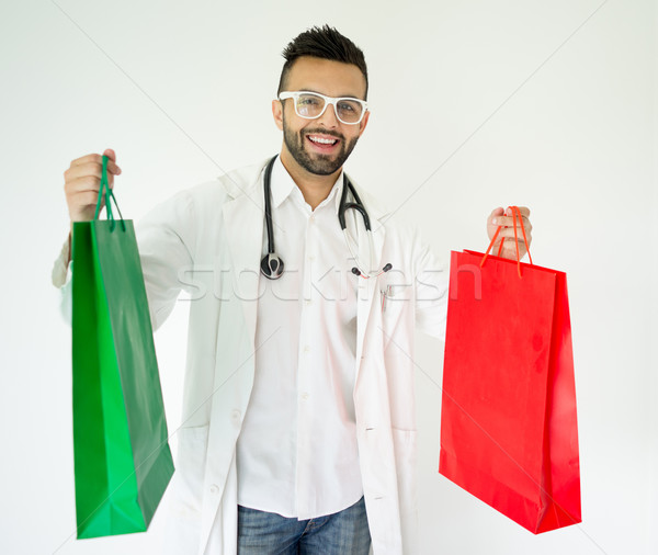 Handsome young male doctor with shopping bags for presents Stock photo © zurijeta