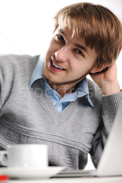 Jeune homme utilisant un ordinateur portable tapant tasse café [[stock_photo]] © zurijeta