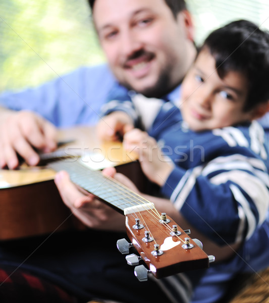 Stock photo: Father and son playing guitar at home