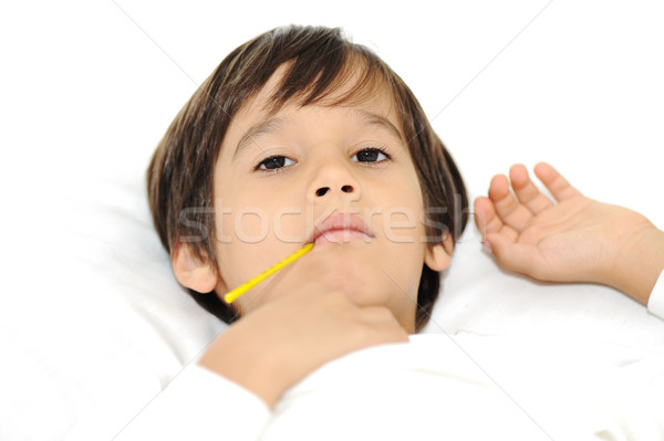 Sick little boy with thermometer, laying on bed Stock photo © zurijeta
