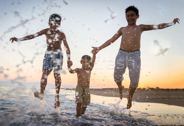 Fun kids playing splash at beach Stock photo © zurijeta
