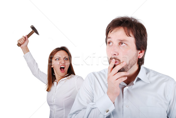 Young attractive female about to hit male from the back with hammer Stock photo © zurijeta
