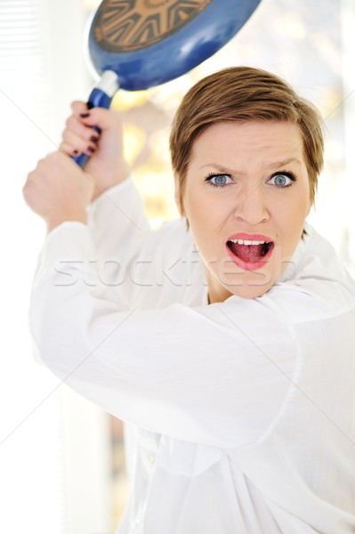 Mad woman with pan in hands Stock photo © zurijeta