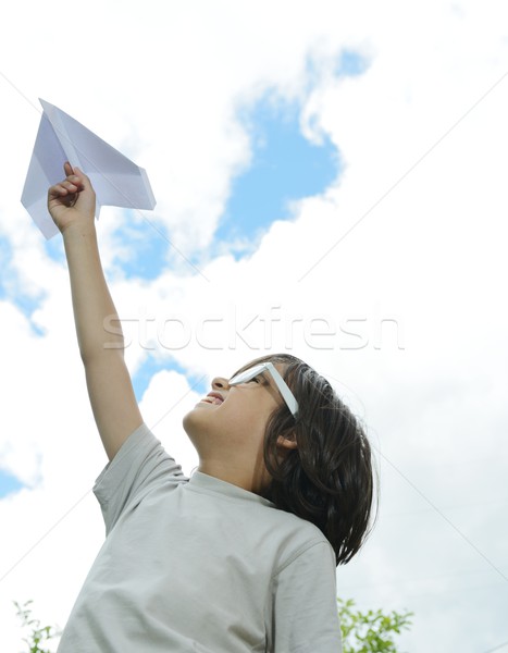 Kid flying a paper airplane Stock photo © zurijeta