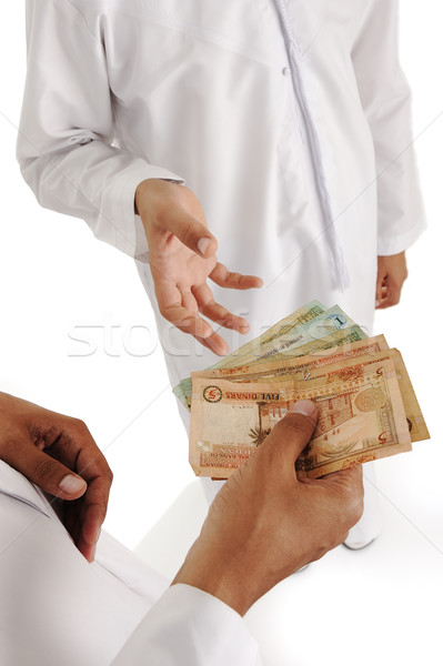 Arabic people, islamic zakat or sadaka, adult giving money to child Stock photo © zurijeta
