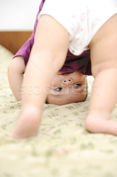 Baby boy playing upside down in bedroom Stock photo © zurijeta