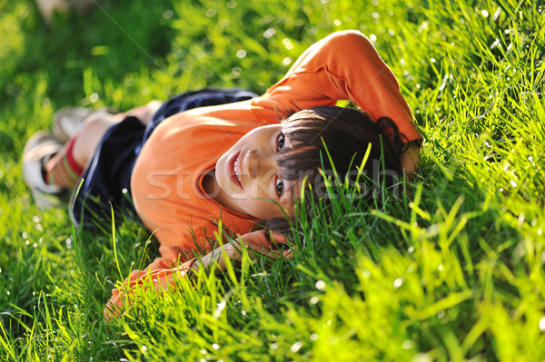 Happy boy laying on beautiful morning green grass Stock photo © zurijeta