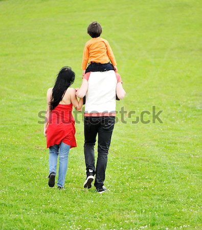 Young family having a walk in the sun over the meadow on a bright summer day Stock photo © zurijeta