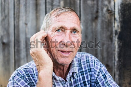 Desperate senior man suffering and covering face with hands in d Stock photo © zurijeta