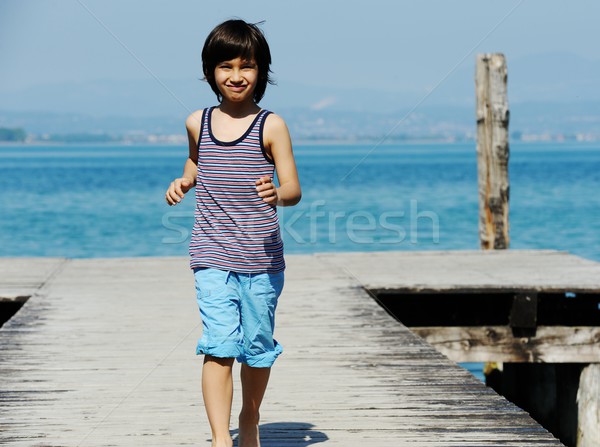 Kicsi fiú sétál dokk gyönyörű tenger Stock fotó © zurijeta