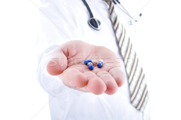 Doctor holiding pills on his palm Stock photo © zurijeta