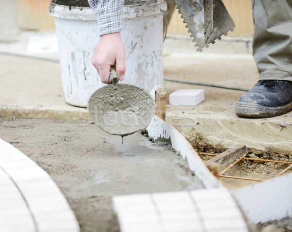 Mason worker making sidewalk pavement with stone blocks Stock photo © zurijeta
