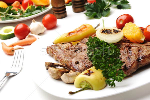 Grilled steak meat on a white plate on white isolated background Stock photo © zurijeta