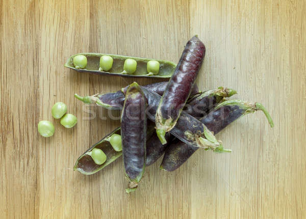 Stock photo: hybrid violet peas in closeup on a wooden background

